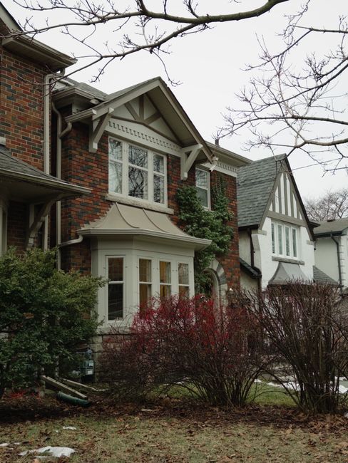 A multi-story Victorian-style house with a brick facade and decorative white timbering, situated on Blackstock Road. The house features a prominent bay window with multiple panes at the ground level, 