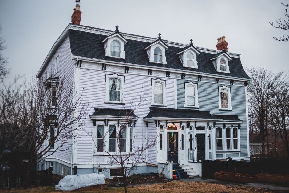 A multi-story Victorian-style house with a brick facade and decorative white timbering, situated on Blackstock Road. The house features a prominent bay window with multiple panes at the ground level, 